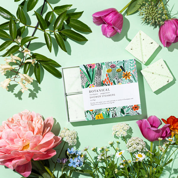 Floral arrangement with a botanical-themed product on a light green background